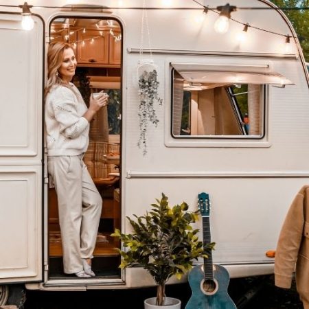 Woman drinking coffee in the door of her tiny home